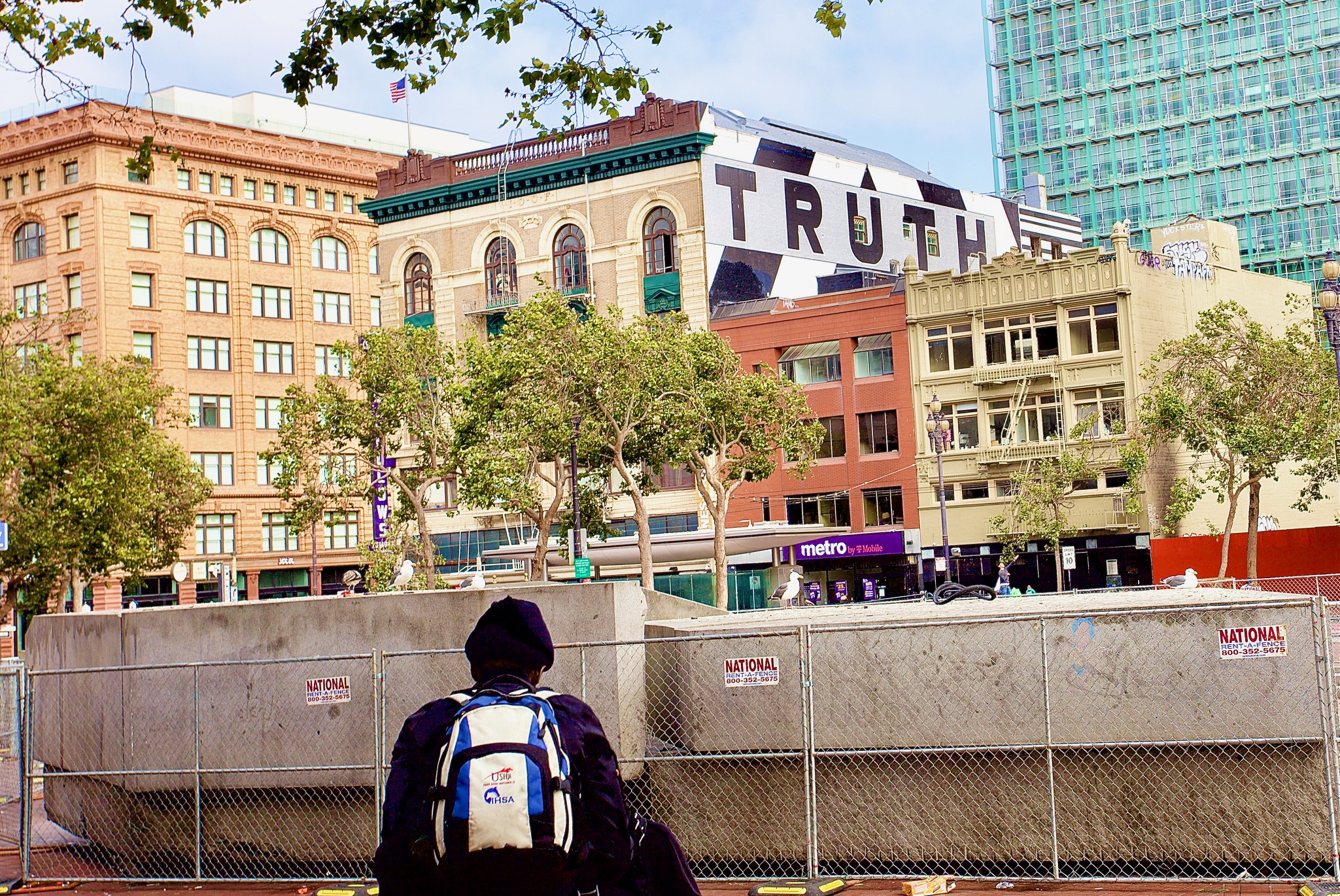 A person from the back, looking over a concrete wall to a sign that says Truth.