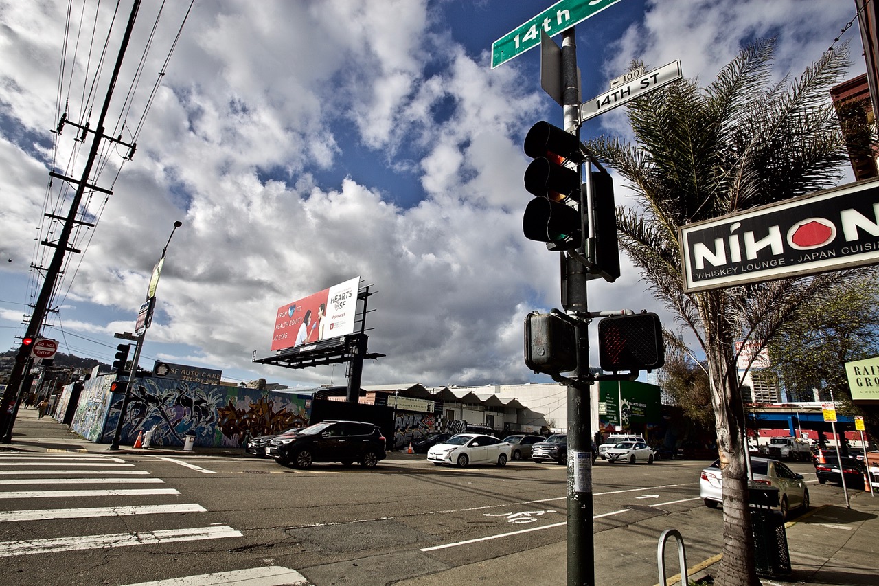 A street light with a sign on it. Dramatic clouds in the sky.