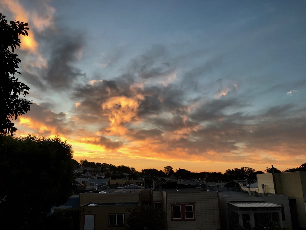 Sunset clouds over a neighborhood of houses.