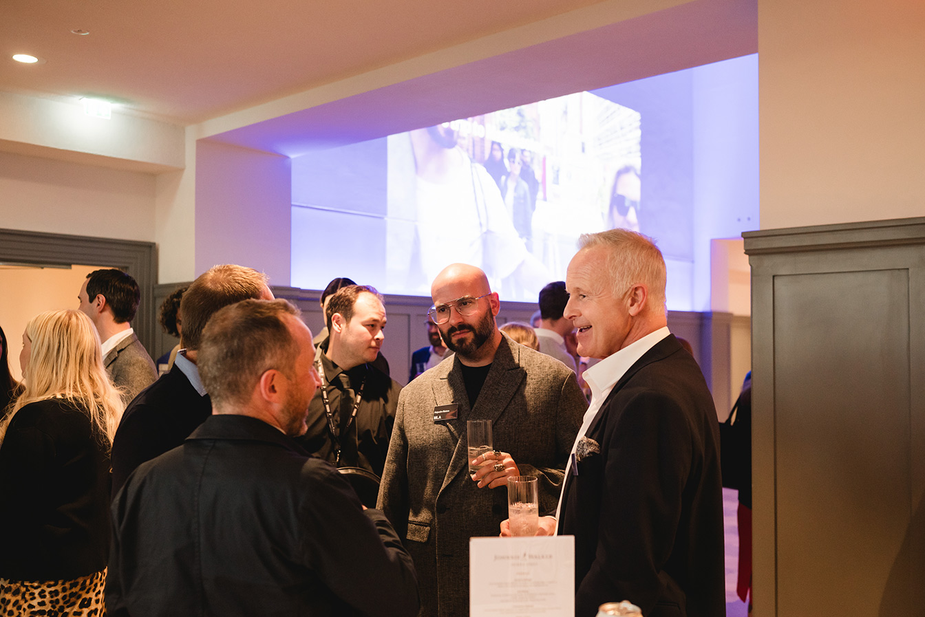 A group of men talking at an event.