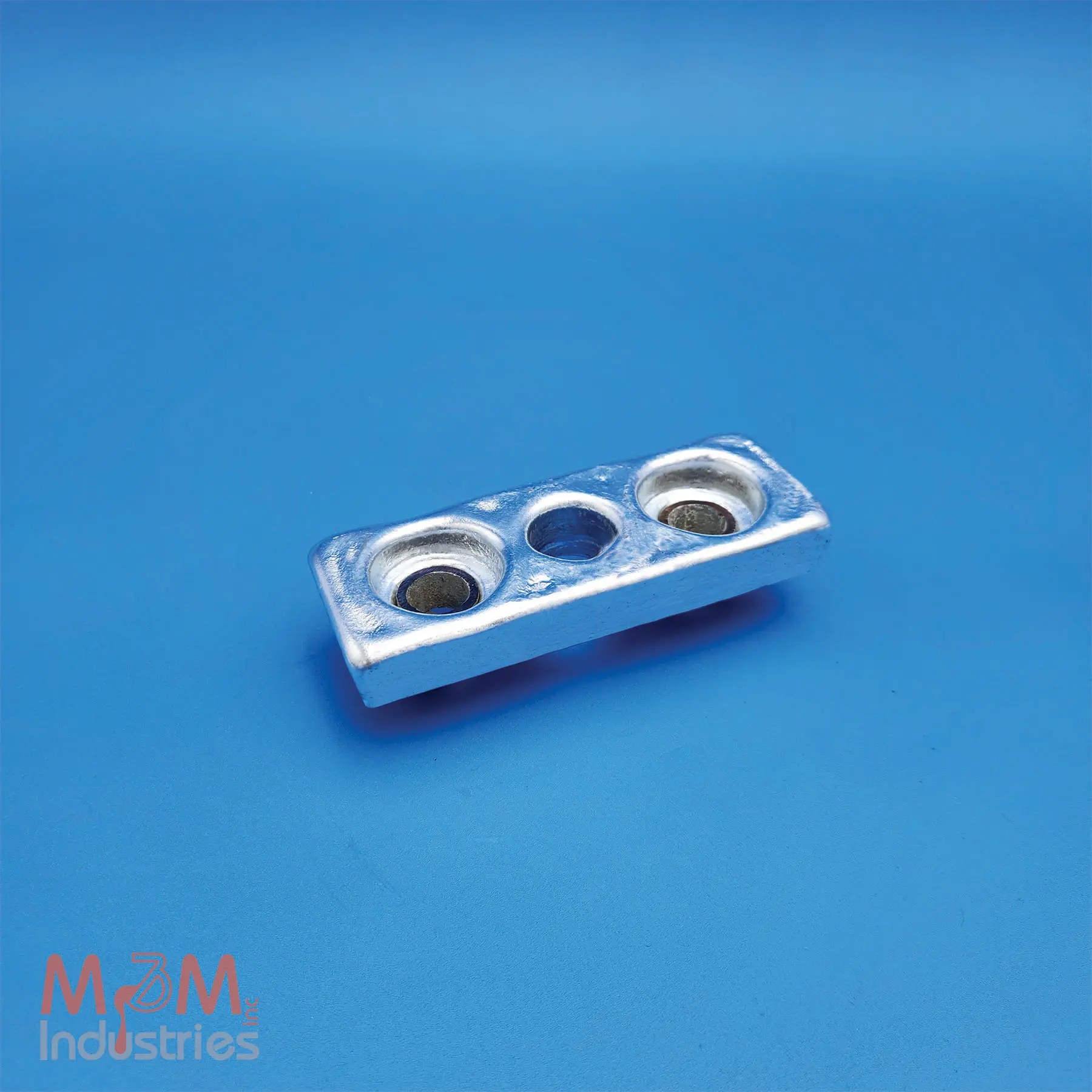 The ZKC-3 Keel Cooler Zinc Sacrificial Anode measures 5" x 2" x ¾" and weighs 1.7 lbs. M&M Industries manufactures each ZKC-3 in the USA from high purity MIL-A-18001 zinc alloy providing dependable cathodic protection. Our team gravity casts every ZKC-3 anode in a controlled U.S. foundry. This proven method ensures consistent alloy chemistry, dimensional accuracy, and effective corrosion protection. M&M equips each ZKC-3 anode with two galvanized steel pipe cores featuring a 0.62" inside diameter (ID), allowing for secure mounting on keel coolers and other marine equipment. The pipe cores position the mounting holes 3-¼" center-to-center and provide a 7/8" diameter center hole to simplify installation with straightforward mounting configurations. The ZKC-3 helps protect keel coolers, heat exchangers, and other submerged metal components from galvanic corrosion, extending equipment service life and reducing maintenance requirements.