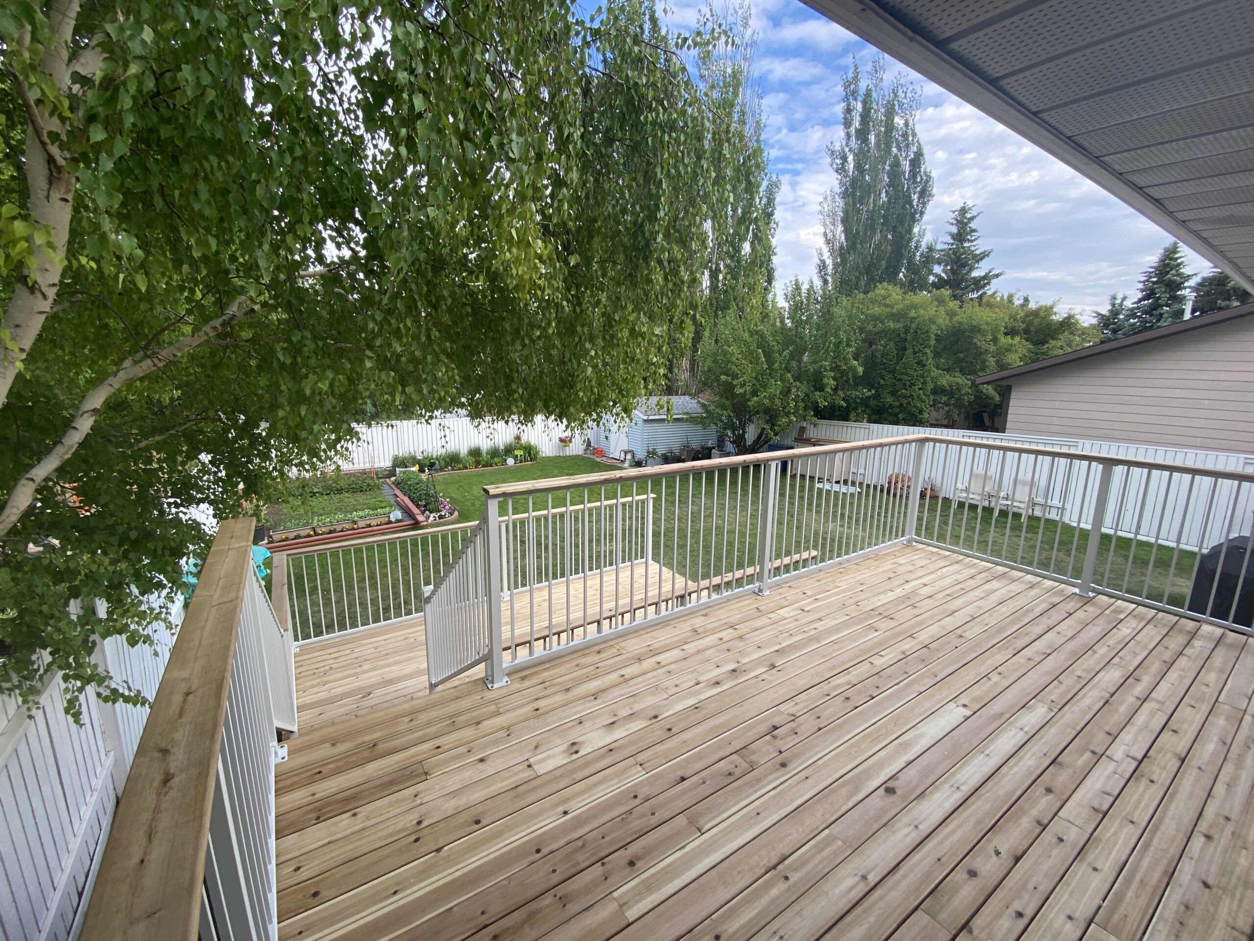 Large cedar deck with white aluminum railing and cedar cocktail rail