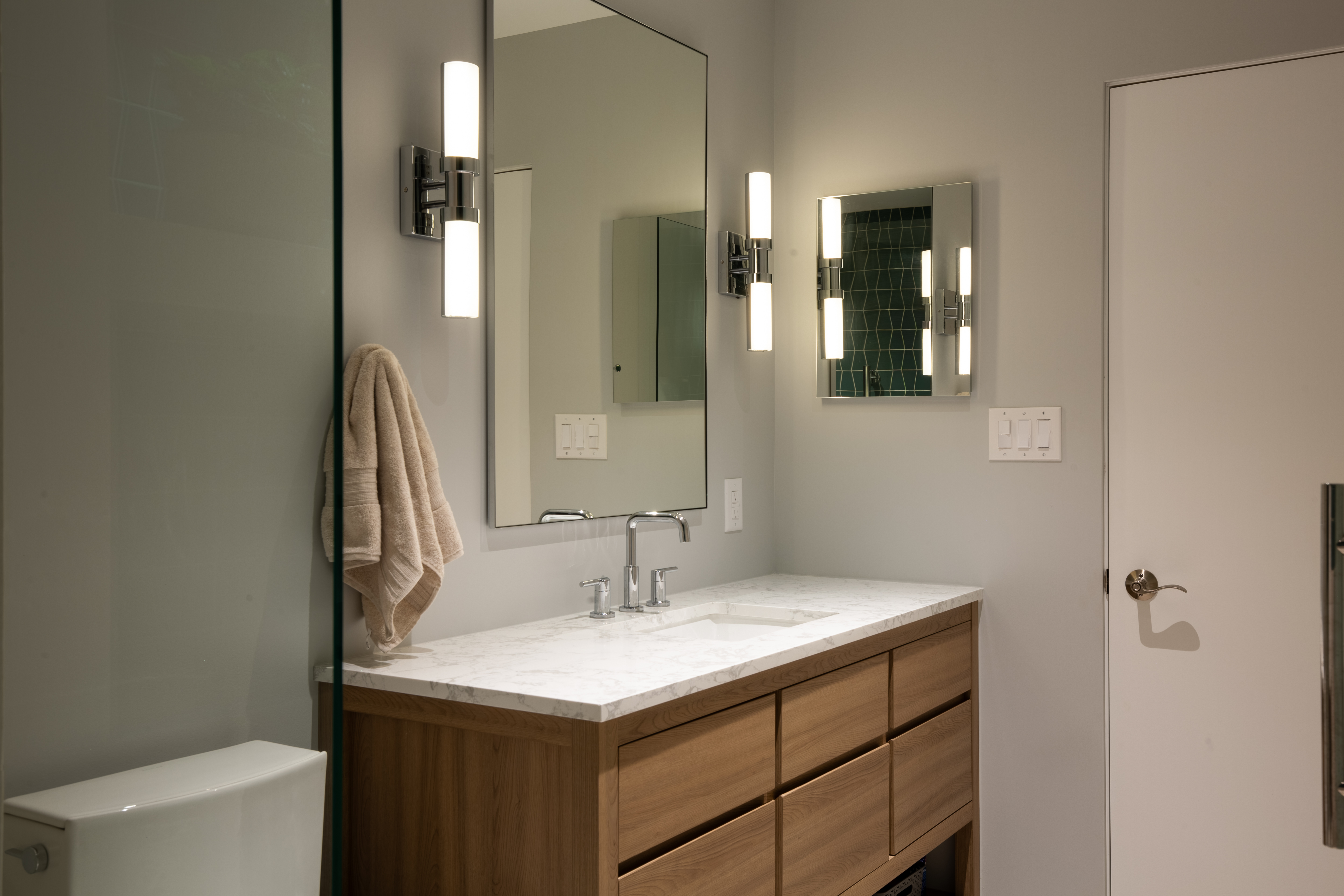 Vanity with a large mirror and one medicine cabinet on the right