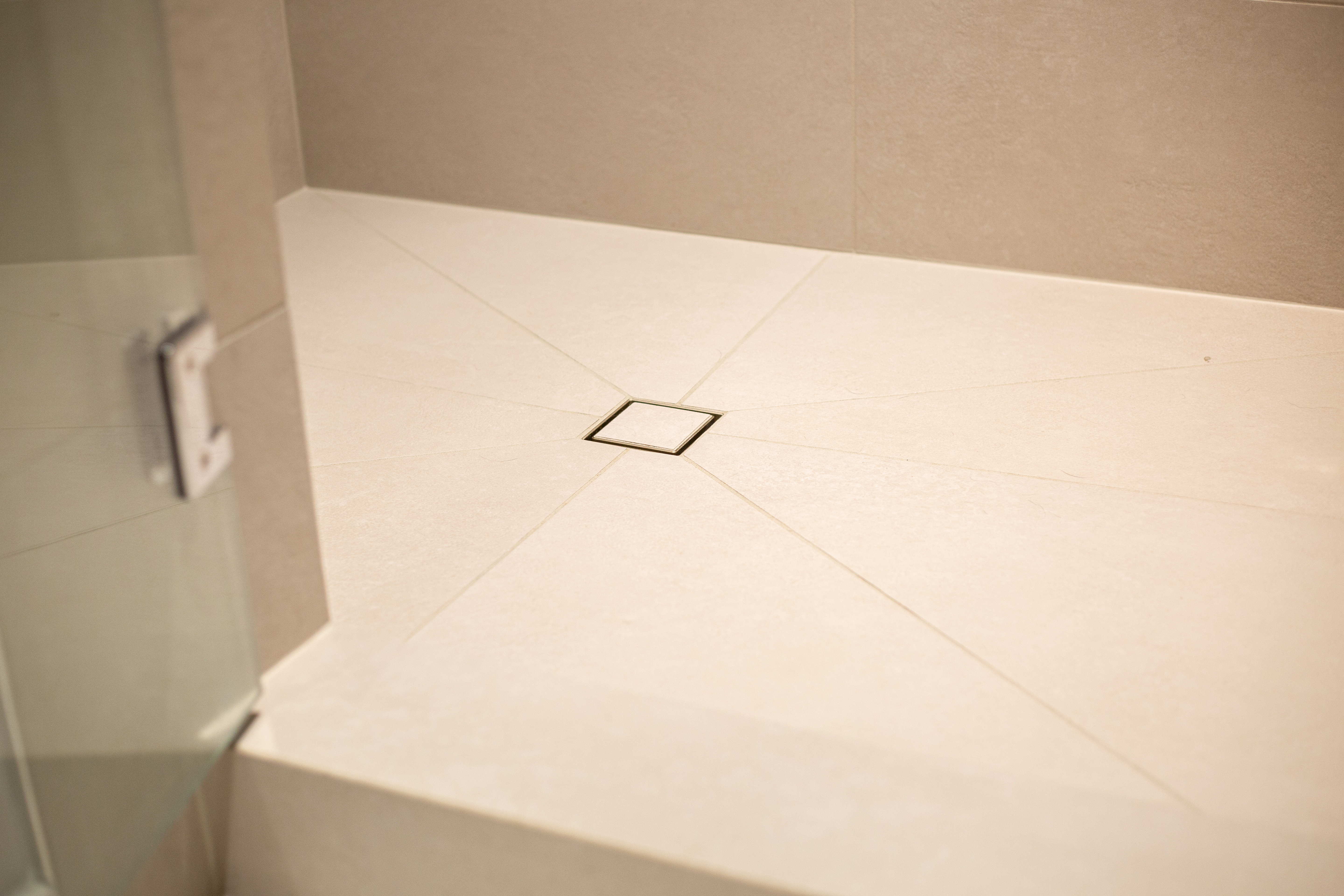 Light tiled shower floor with a discreet square drain