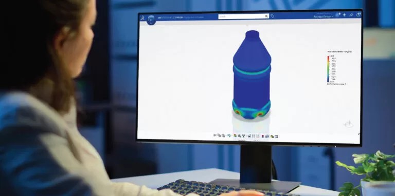 Engineer using simulation software on computer to analyze plastic bottle stress distribution in product design process