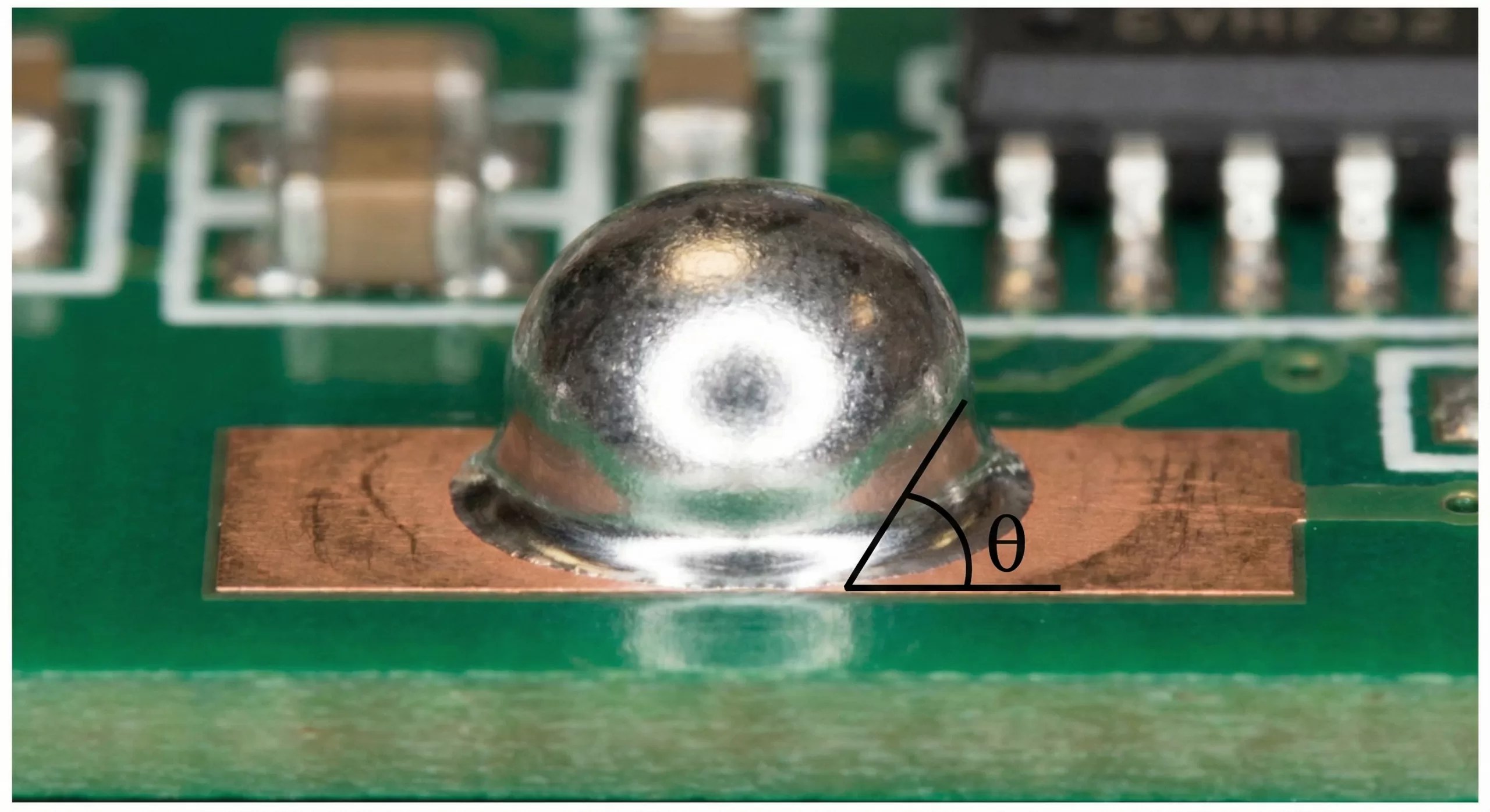 Close-up of a solder ball on a PCB demonstrating the contact angle (theta) and wetting properties, relevant for surface tension simulation in electronics manufacturing.