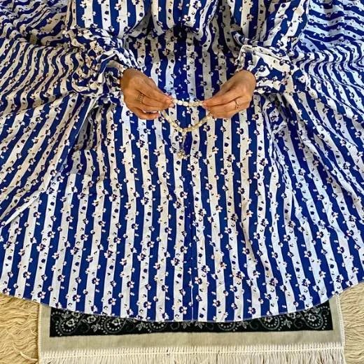 A woman using a Winter Namaz Chadar, performing namaz. Modify.pk