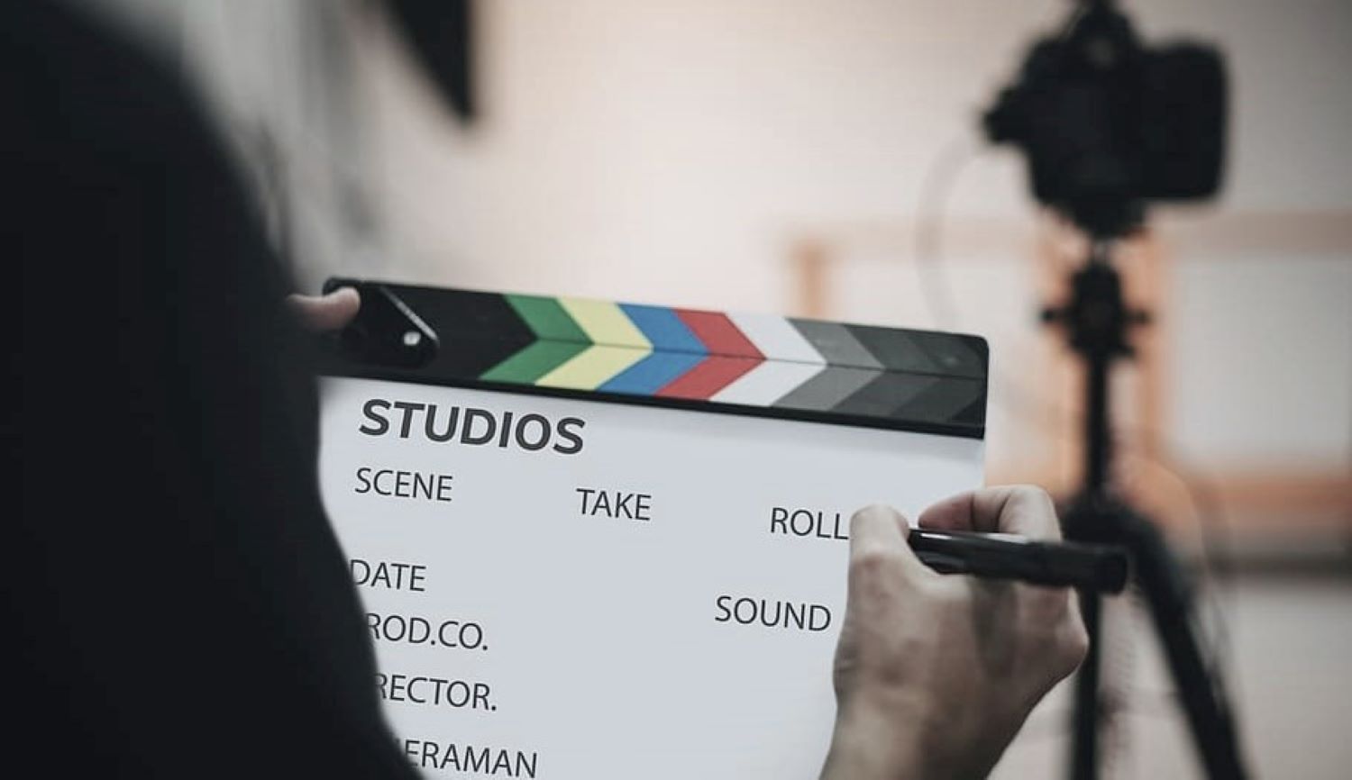 Person writing on a clapboard on a film set.