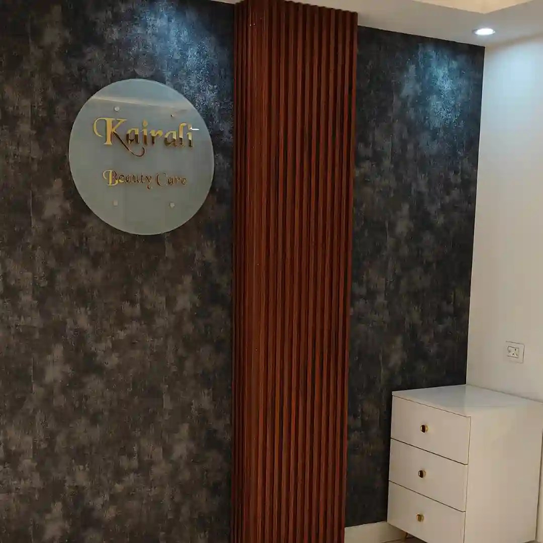 Modern salon reception area with a "Kairali Beauty Care" sign, textured wall, and wooden paneling, ideal for beauty spas in Delhi, Gurgaon, and Noida