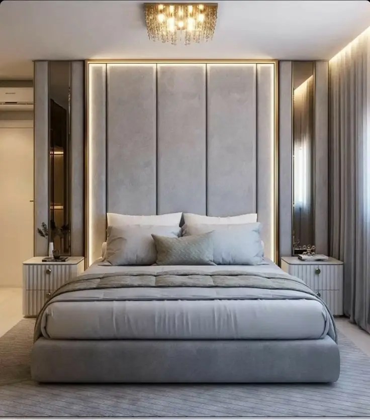 Luxury bedroom with a gray upholstered bed, LED-lit headboard, and modern bedside tables, ideal for homes in Delhi, Gurgaon, and Noida.