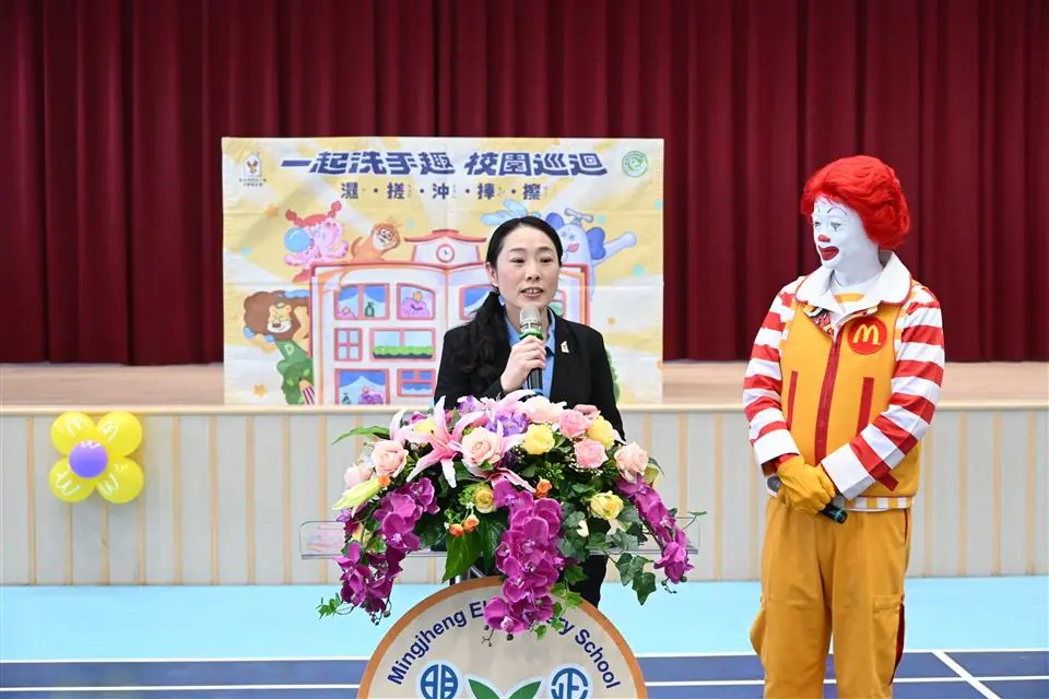 麥當勞叔叔在校園與學童互動，示範正確洗手步驟預防腸病毒。