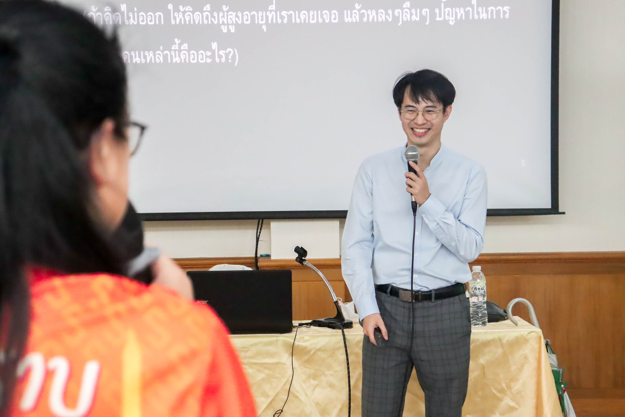 นพ. ประภัทร เลิศฤาชาชัย ถือไมโครโฟนบรรยายหน้าห้องประชุม