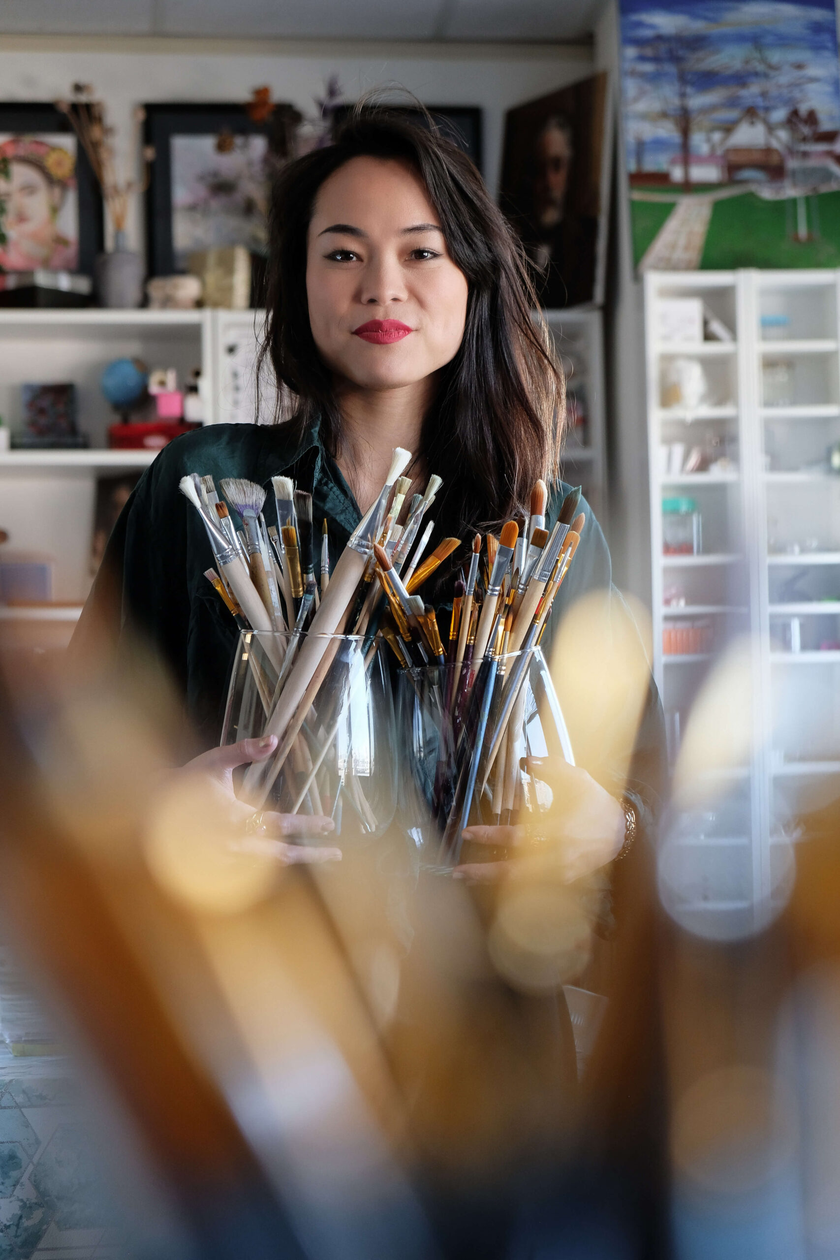 Beautiful Asian artist keeping brushes
