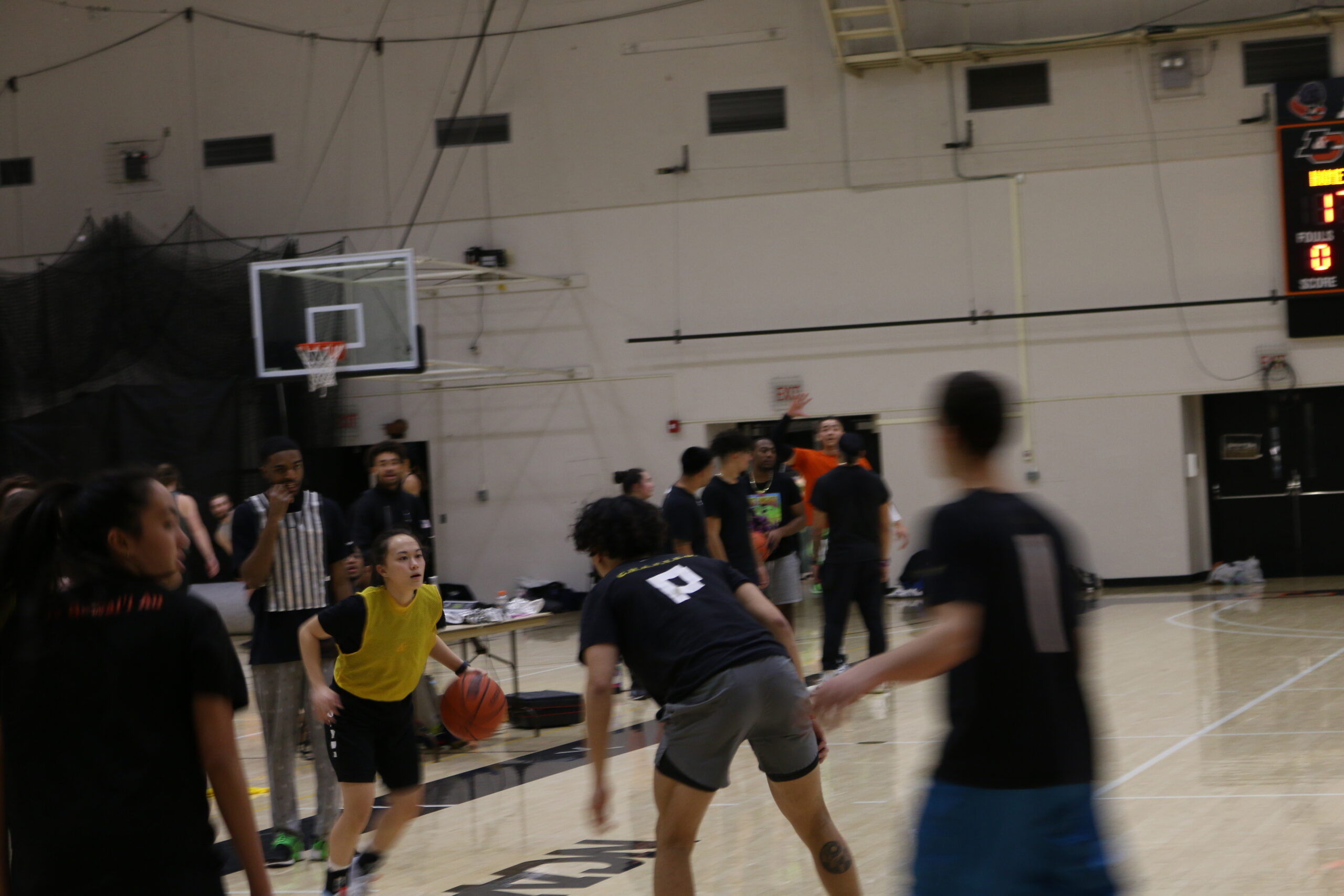 Photo of students playing basketball in intramural uniform (jerseys/non-jerseys)