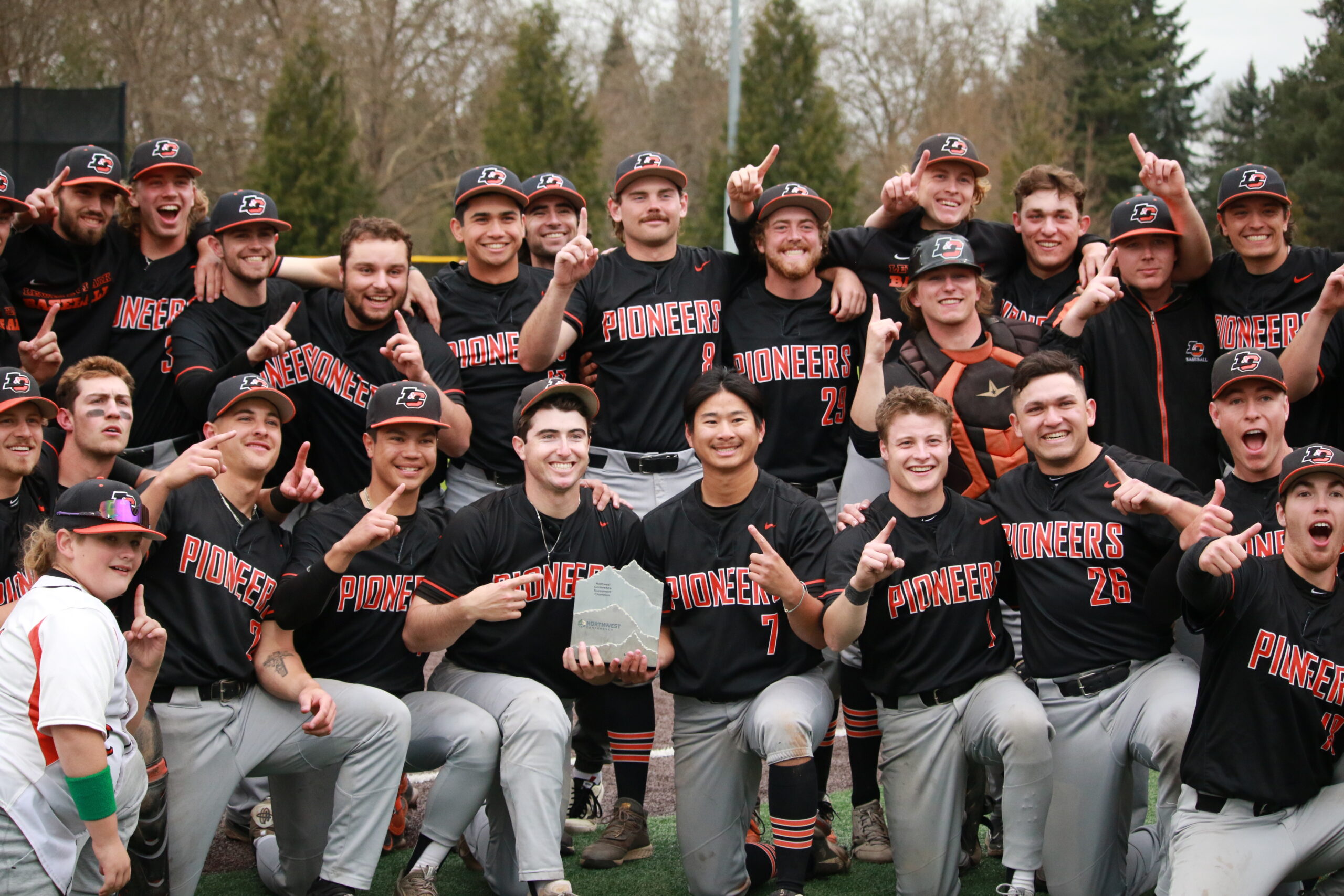 Photo of the baseball team posing with the trophy