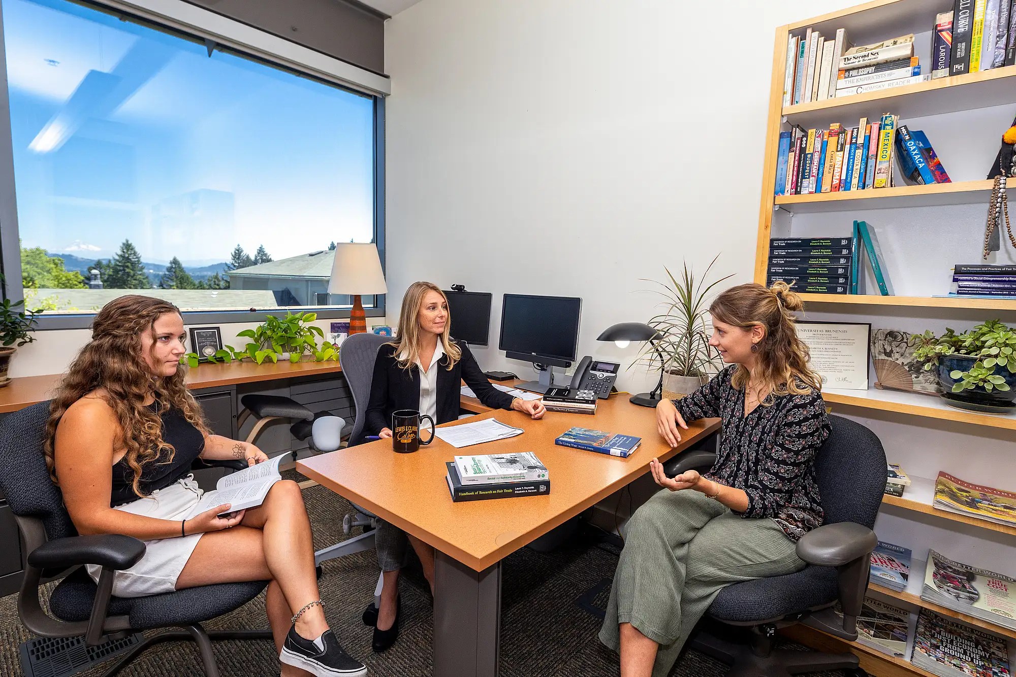 Photo of students meeting in an office with a faculty member.