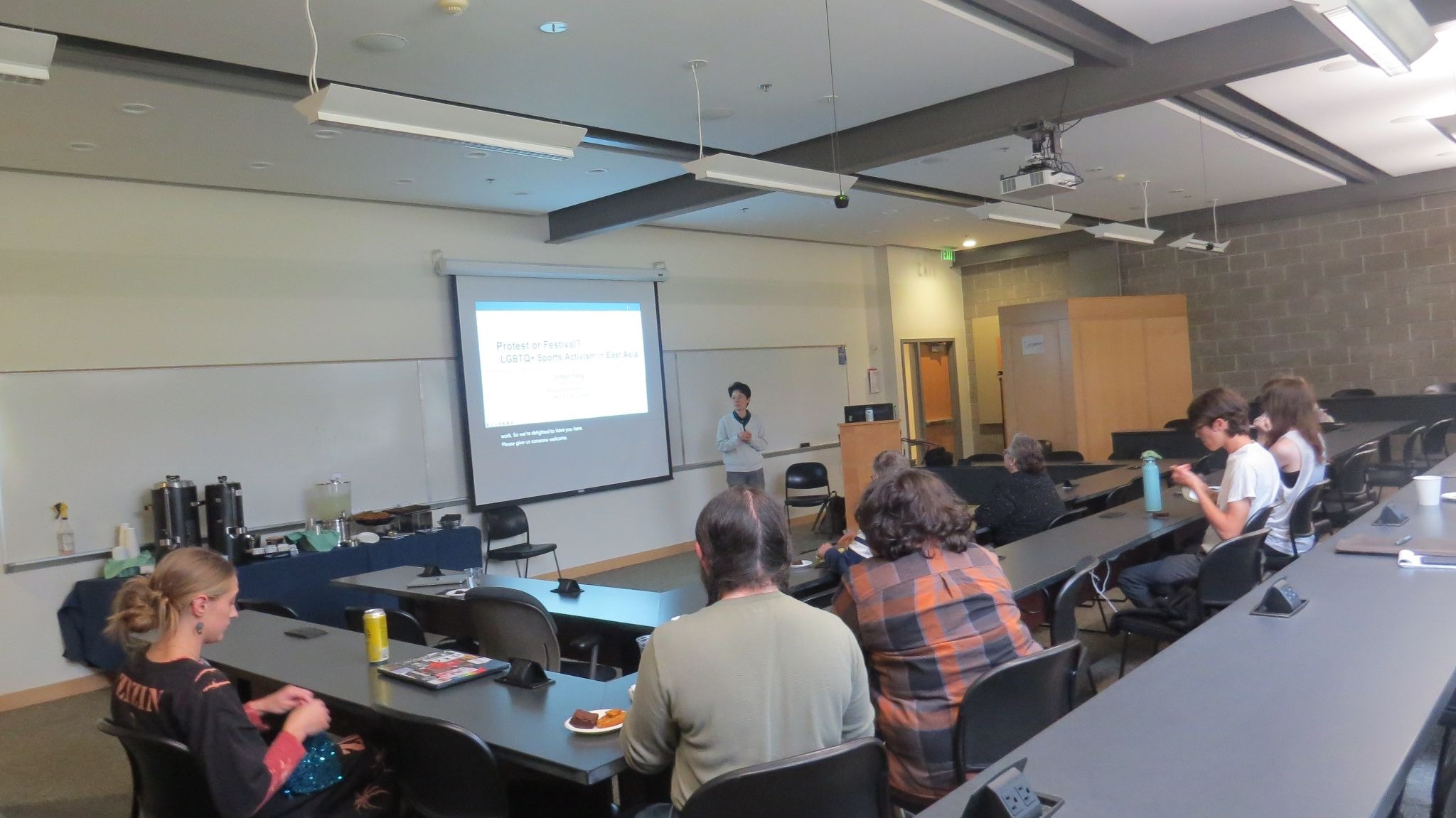 Jinsun Yang speaking in lecture hall at colloquium event