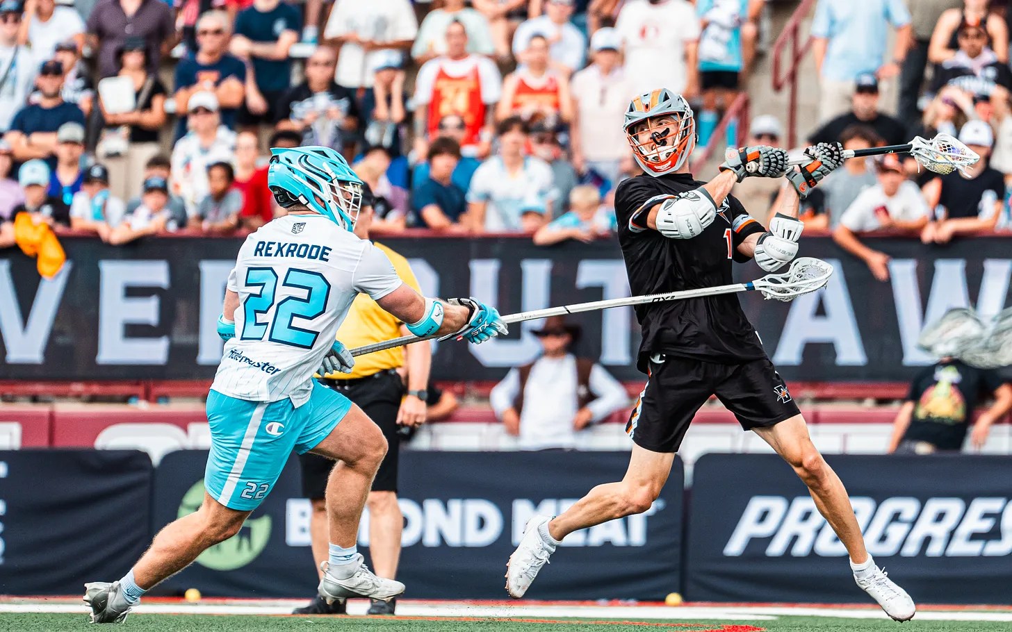 Lacrosse player throws a ball as two defenders gaurd him