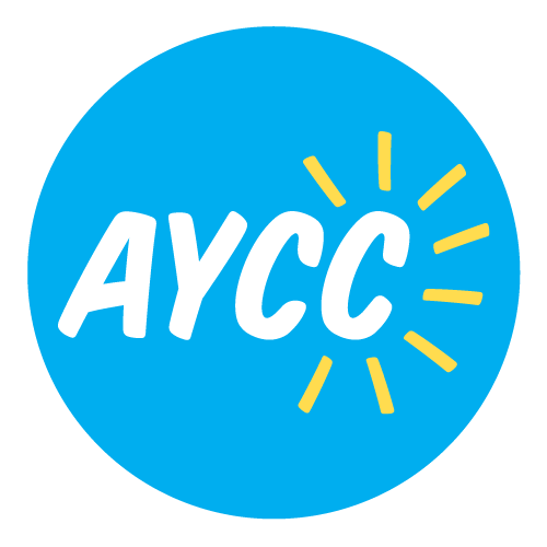 AYCC logo. White text reading AYCC in a blue circle, yellow lines spike out from the text like sun rays.