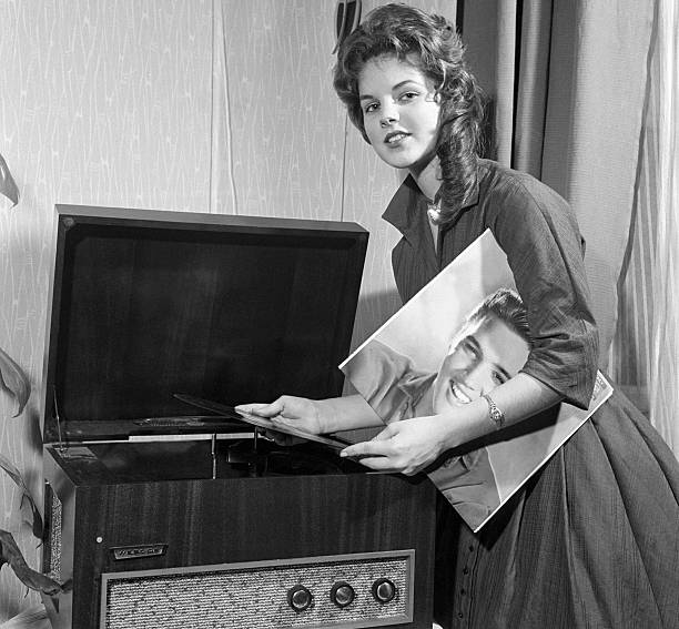 Priscilla Beaulieu, Elvis Presley's "girl back home," plays a record album by the teen idol. Elvis was serving in the US Army in Germany. The couple were married in 1967 and divorced in 1973. Photo Credit: Getty Images