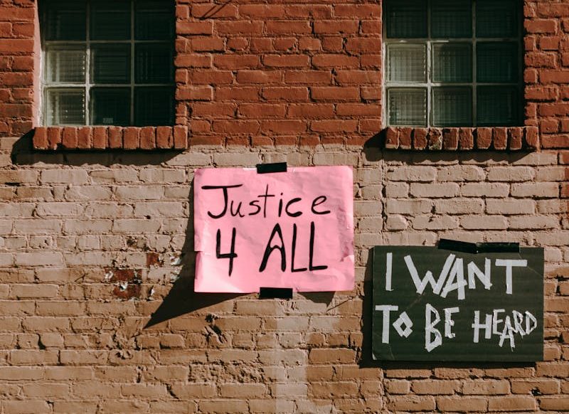 Street activism signs on a brick wall promoting social justice and freedom of speech