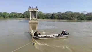 Equipes de mergulho dos bombeiros utilizam barco para vistoriar área onde caminhão caiu após desabamento de ponte no Rio Taquari