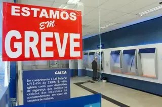 Faixas de greve em agência dos Correios com mensagem de paralisação por tempo indeterminado