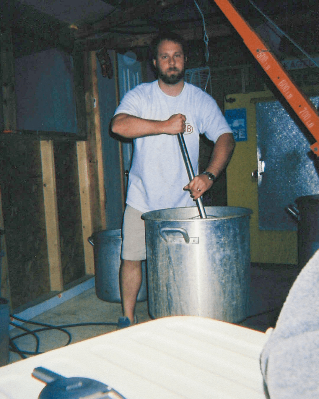 Early days of Mudbugs Crawfish with the founder stirring a large seafood boil