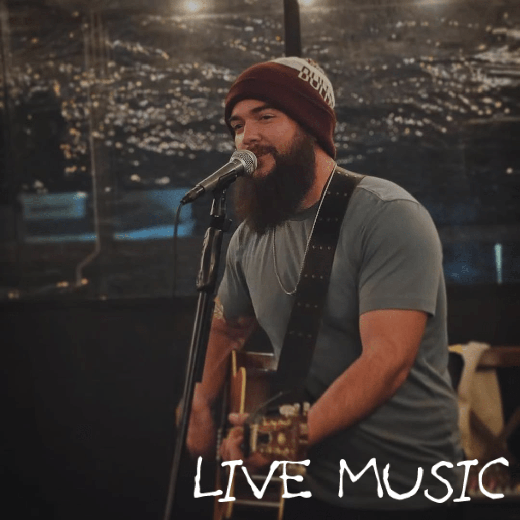 Live music performance at Mudbugs Crawfish featuring a guitarist singing on stage