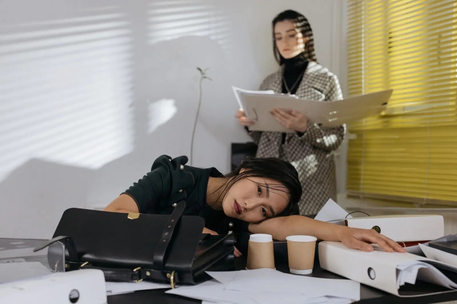 A woman quietly exhausted at work in an office