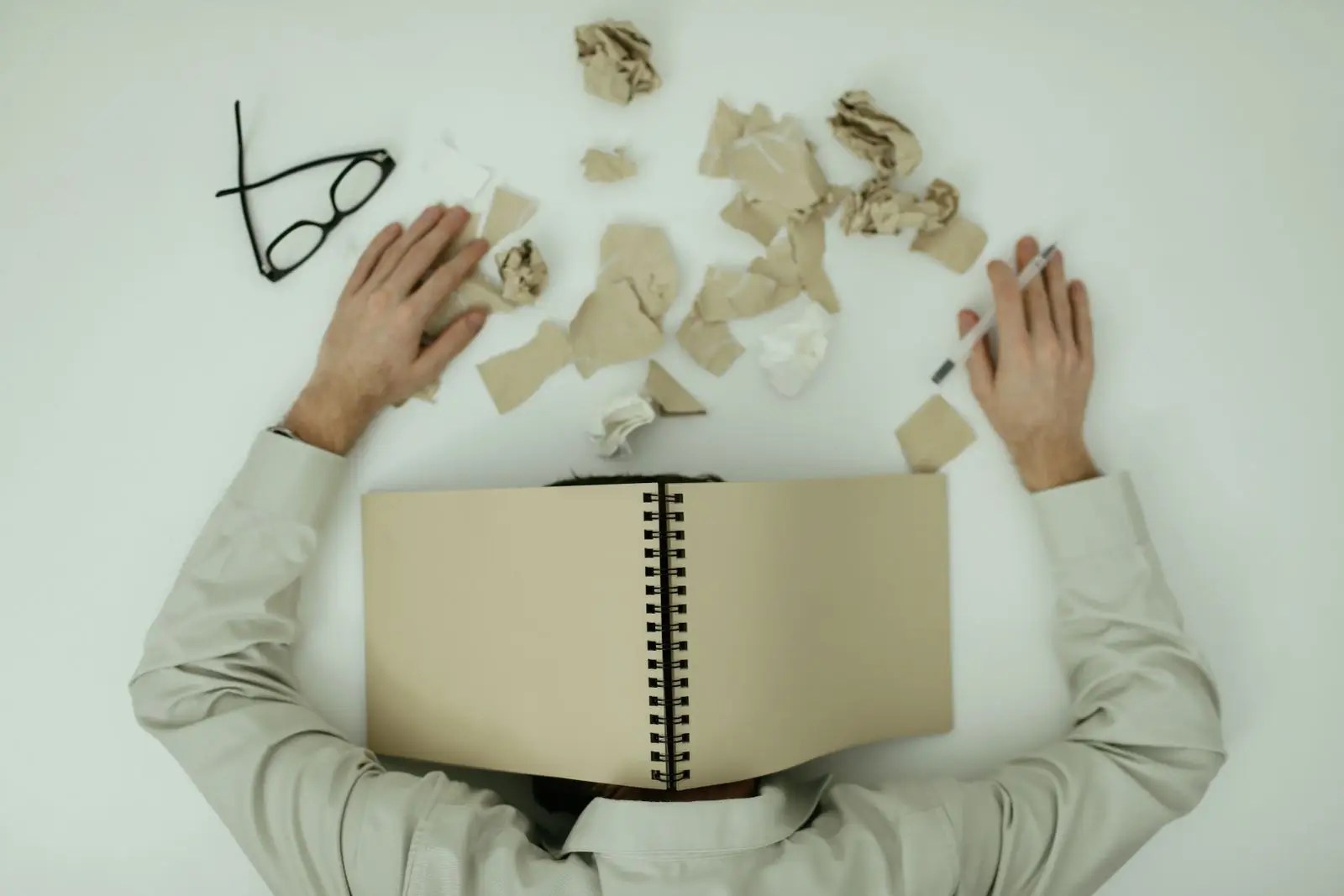 A man resting his head on a table, emotionally depleted