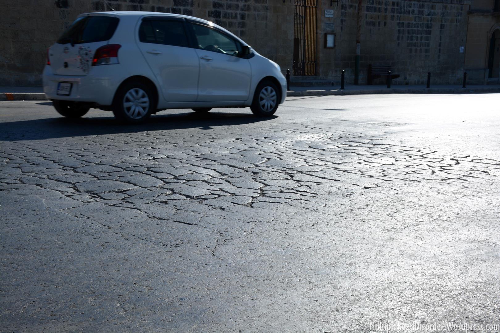A very small example of the awful road conditions all over the island. Glass like surface covered in potholes!