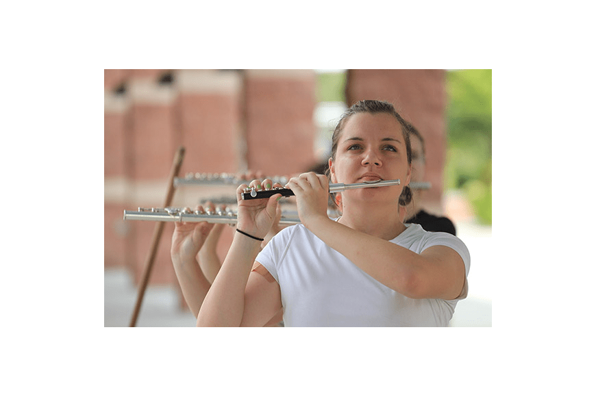 a girl playing a piccolo while marching