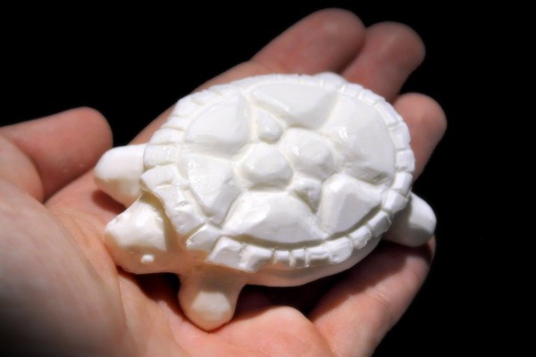 White carved turtle in a hand.