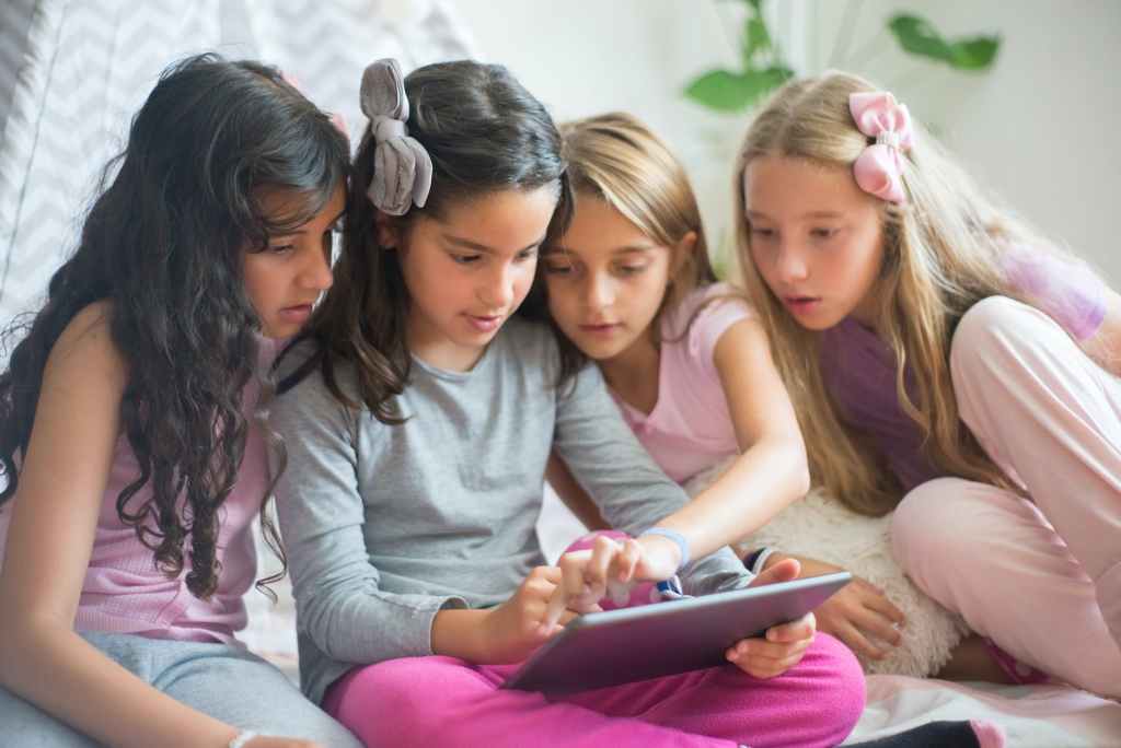 close up shot of four girls looking at the ipad