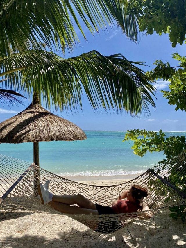 young woman relaxing on a hamock on a beach in Mauritius