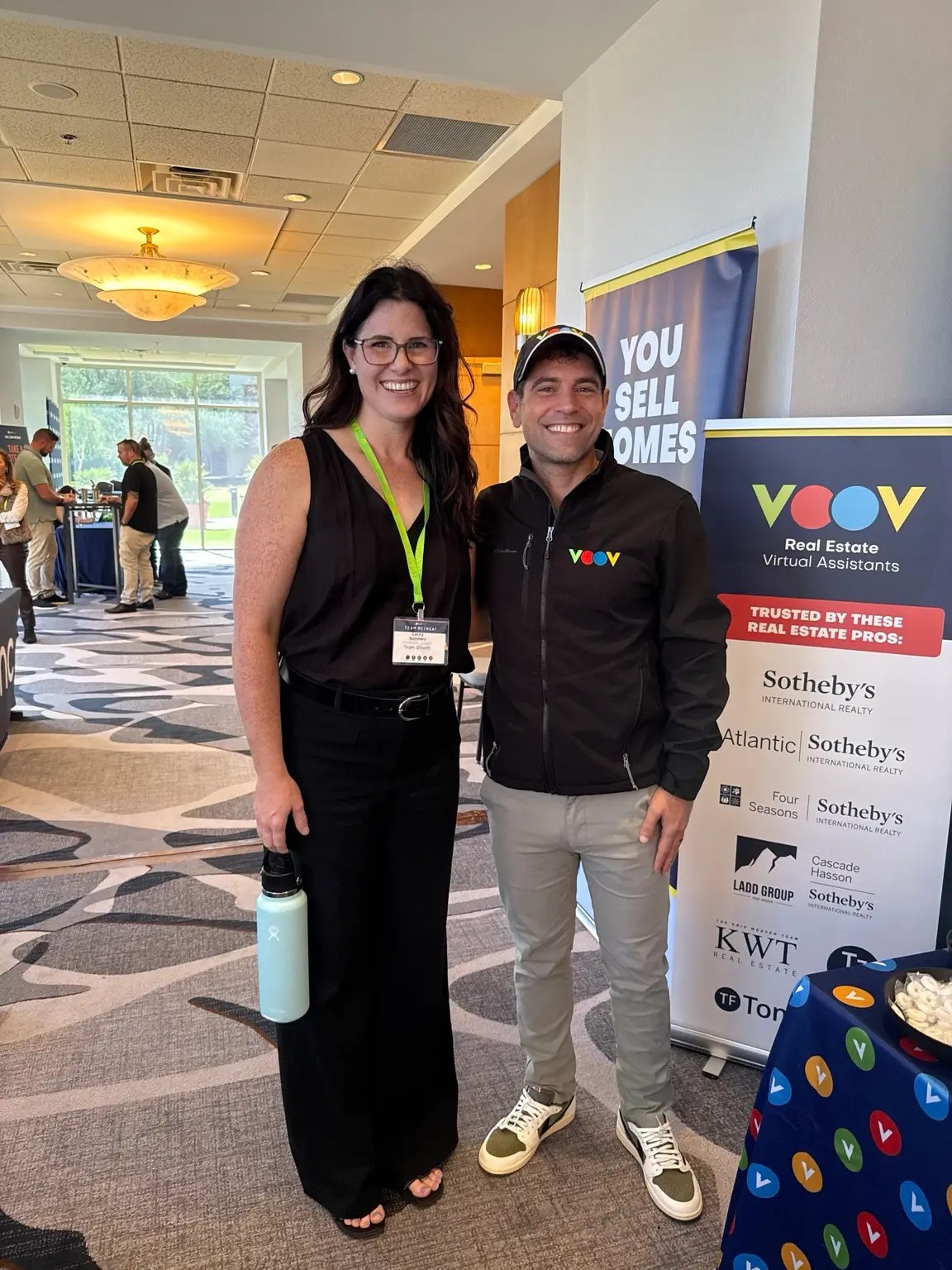 Two event participants pausing for a photo near the exhibit area