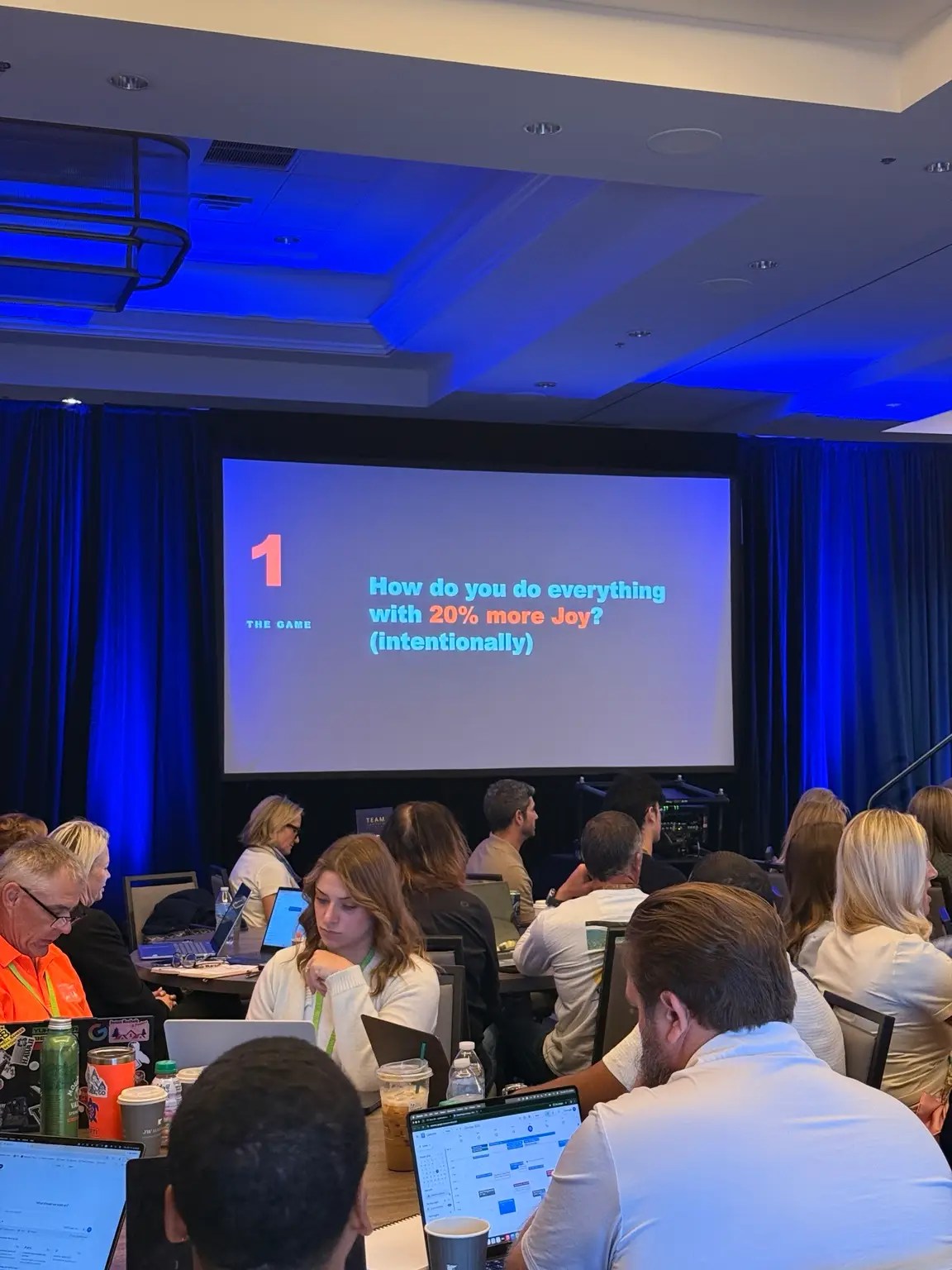 Attendees viewing a presentation about bringing more joy into everyday work