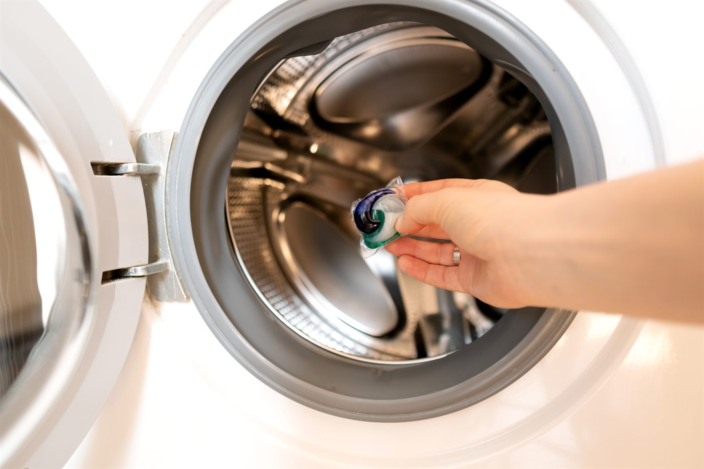 Une capsule de lessive glissée dans le tambour d’un lave-linge