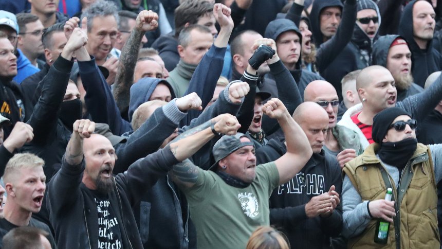 27.08.2018, Sachsen, Chemnitz: Polizisten stehen in der Innenstadt am Karl-Marx-Monument bei einer Kundgebung der rechten Szene, um ein Aufeinanderprallen von rechten und linken Gruppen zu verhindern. Nach einem Streit war in der Nacht zu Sonntag in der Innenstadt ein 35-jähriger Mann erstochen worden. Die Tat war Anlass für spontane Demonstrationen, bei denen es auch zu Jagdszenen und Gewaltausbrüchen kam. Foto: Jan Woitas/dpa +++ dpa-Bildfunk +++
