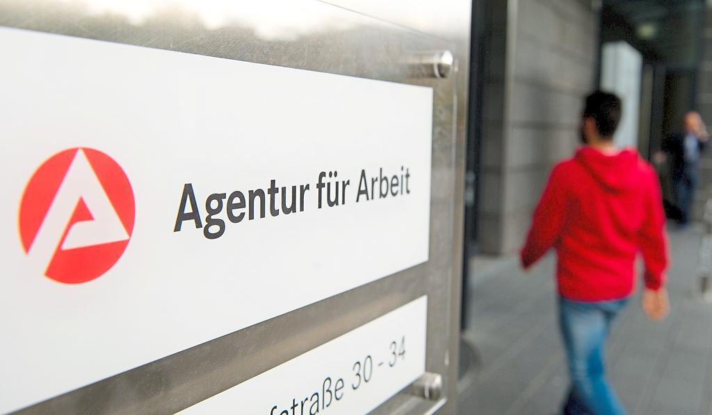 ILLUSTRATION - ARCHIV - 07.10.2014, Baden-Württemberg, Stuttgart: Ein Mann geht hinter dem Schild der Agentur für Arbeit zum Eingang. Die Agentur für Arbeit gibt am 31.01.2018 die Arbeitmarktzahlen für den Monat Januar bekannt. Foto: Sebastian Kahnert/dpa +++ dpa-Bildfunk +++