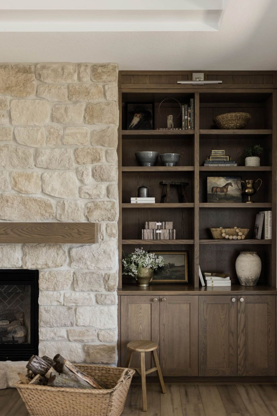 Wood built ins next to stone fireplace. James May Homes