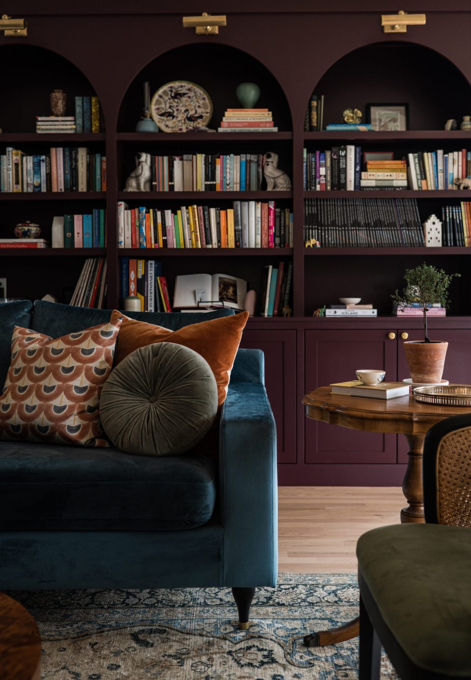 5 tips for adding color to your home. Purple bookcases and teal couch in living room.