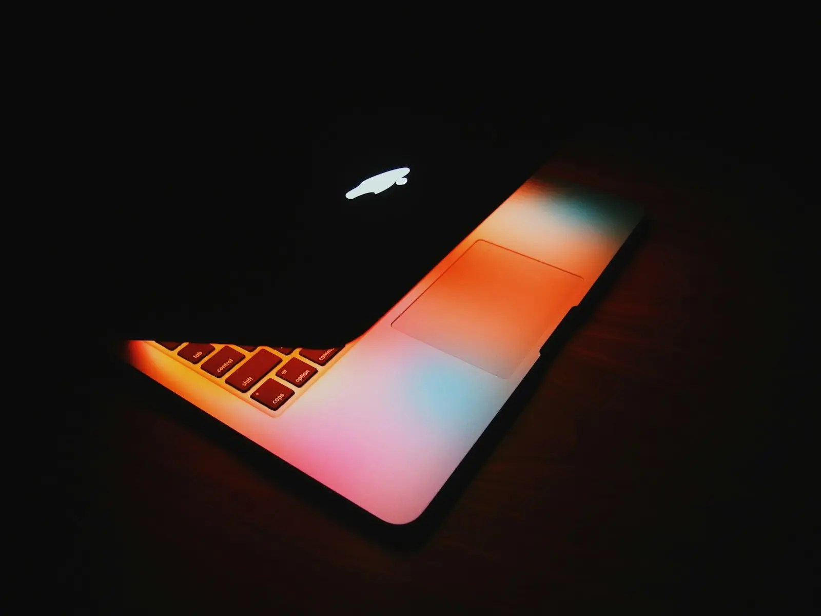 MacBook open on wooden surface