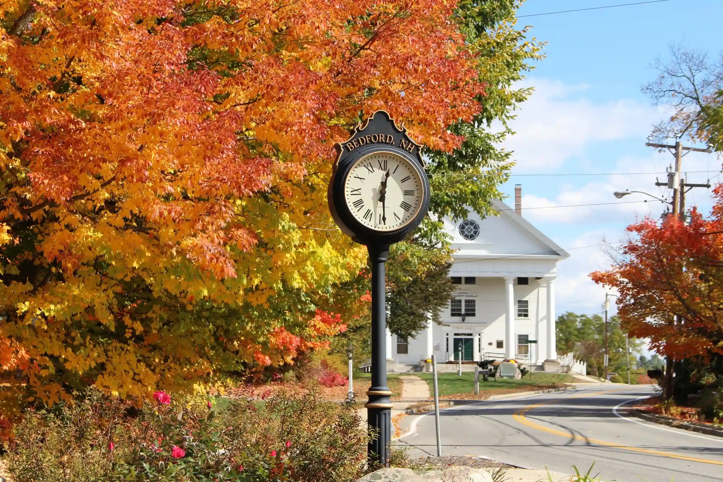 Historic town center clock and autumn trees in Bedford NH, local service area for Nault's Plumbing and Heating