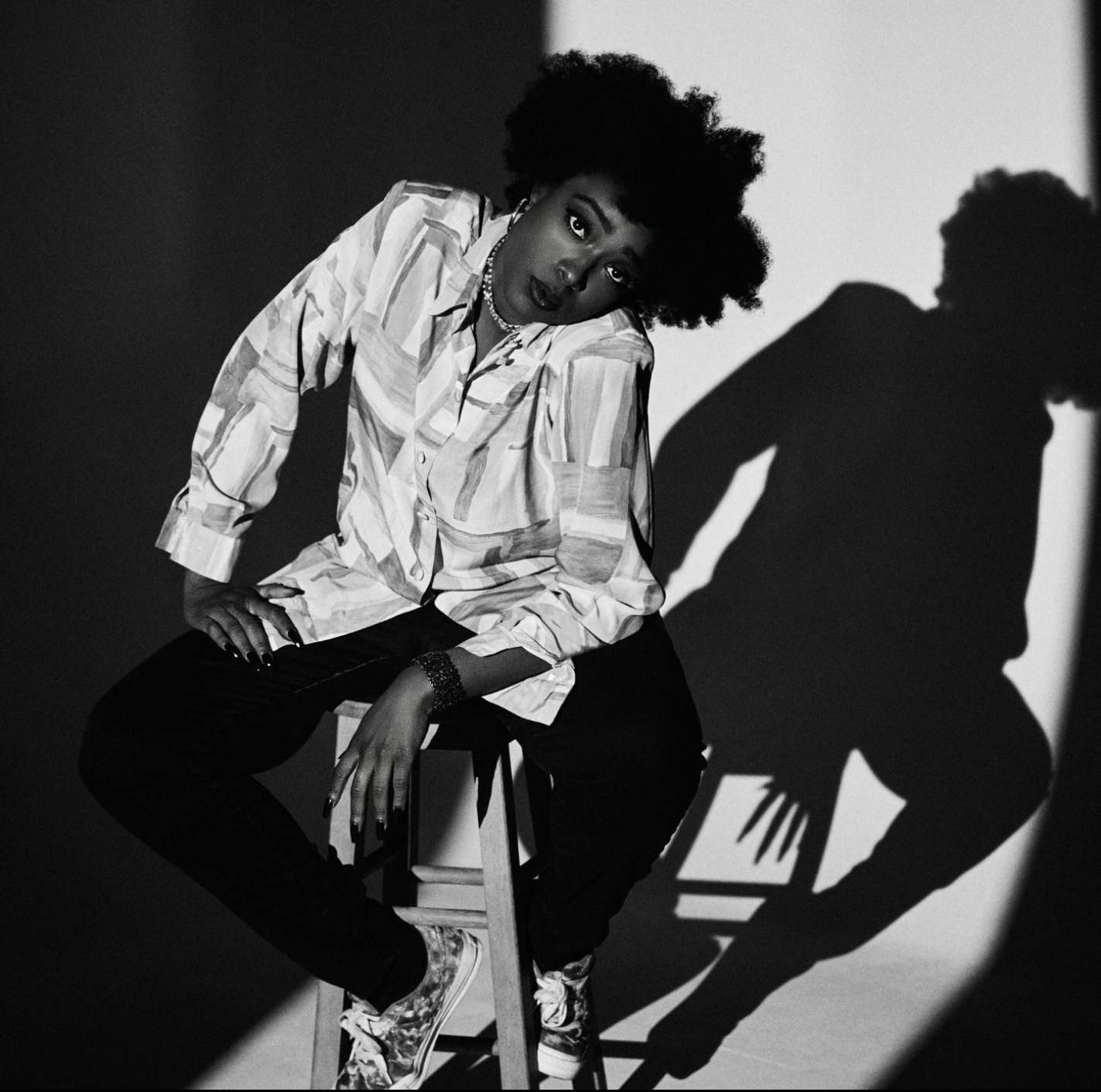 LA Hip Hop Artist Portrait, Queer Rapper, sound designer and actor, LA Sound Designer. Nayla Savannah in a moody black-and-white portrait wearing a mabled blouse and black pants, dramatic shadows framing the shot