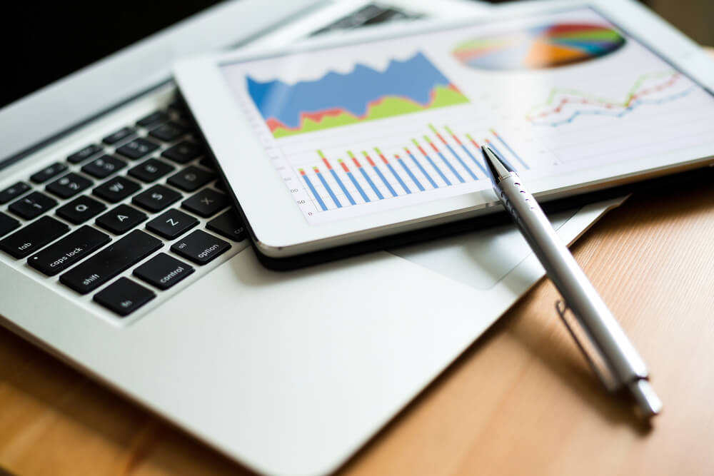 laptop e papéis com gráficos