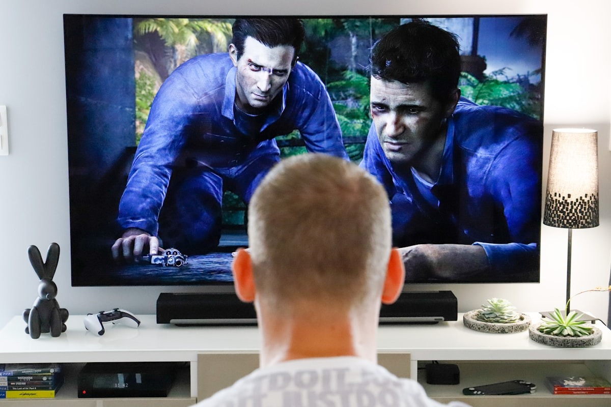 A person sitting in front of a large wall-mounted television in a living room