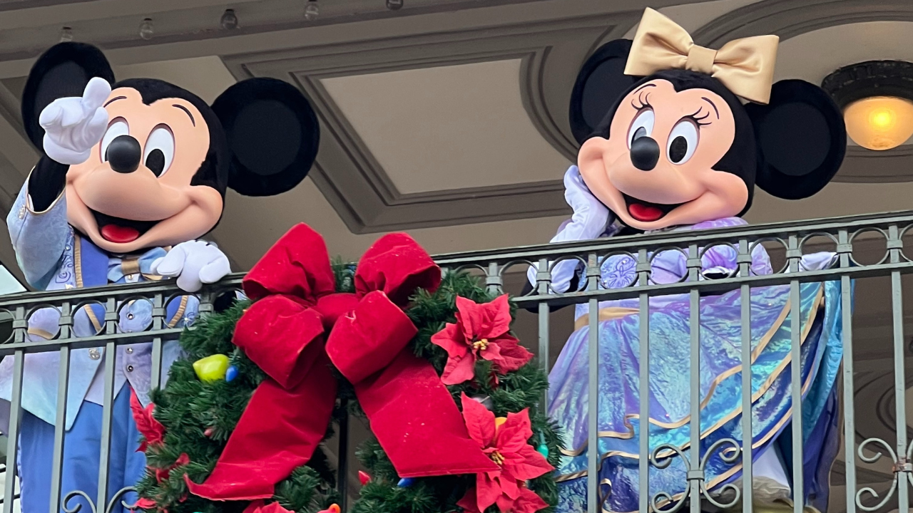 Mickey and Minnie Mouse waving from a balcony at Magic Kingdom during an autism-friendly Walt Disney World visit.