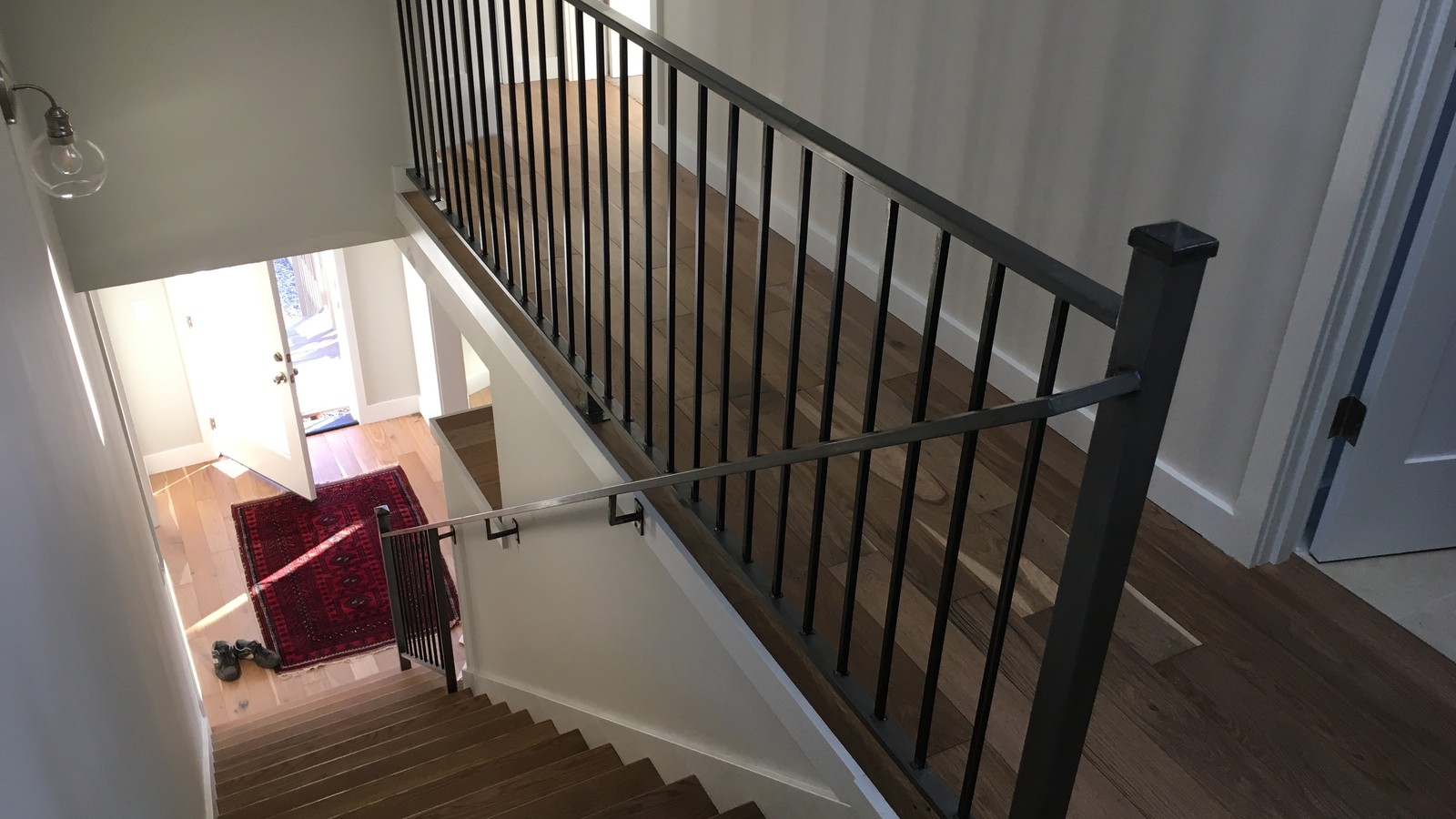 Custom black steel stair and landing railing installed in a modern residential home in Surrey